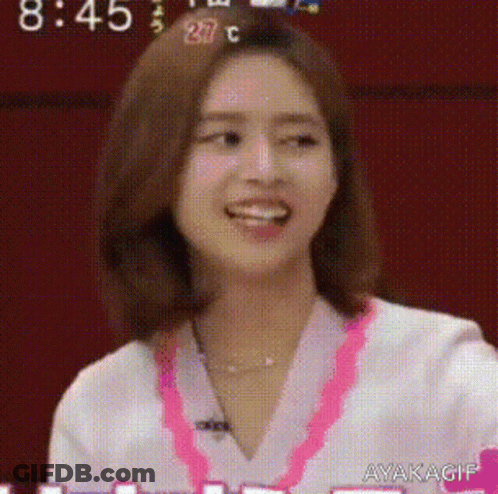 A Close Up Of A Woman 'S Face With A Pink Necklace Around Her Neck . GIF
