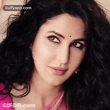 A Close Up Of A Woman 'S Face With A Pink Top And Black Hair . GIF