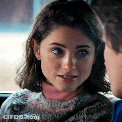 A Close Up Of A Woman 'S Face With A Pink Turtleneck GIF