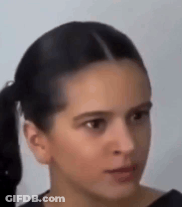 A Close Up Of A Woman 'S Face With A Ponytail And A Serious Look On Her Face . GIF
