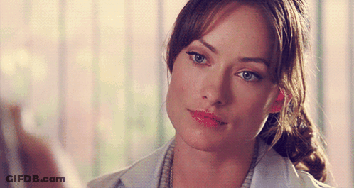 A Close Up Of A Woman 'S Face With A Ponytail And Blue Eyes GIF