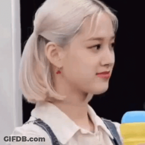 A Close Up Of A Woman 'S Face With A Ponytail And Earrings . GIF