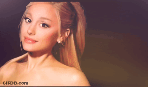 A Close Up Of A Woman 'S Face With A Ponytail And Earrings GIF