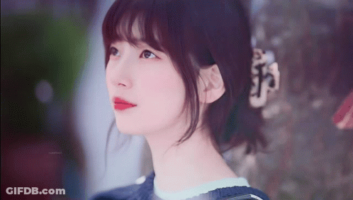 A Close Up Of A Woman 'S Face With A Ponytail And Red Lipstick . GIF
