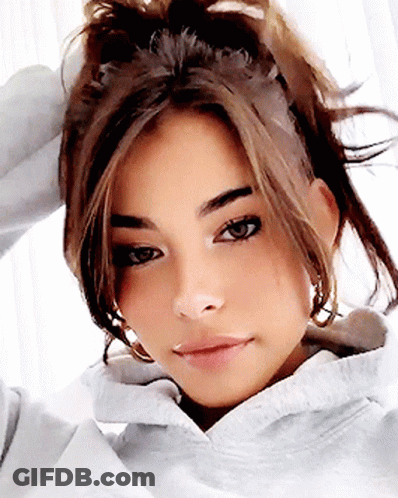 A Close Up Of A Woman 'S Face With A Ponytail GIF