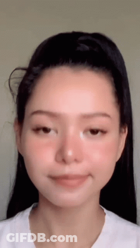 A Close Up Of A Woman 'S Face With A Ponytail . GIF