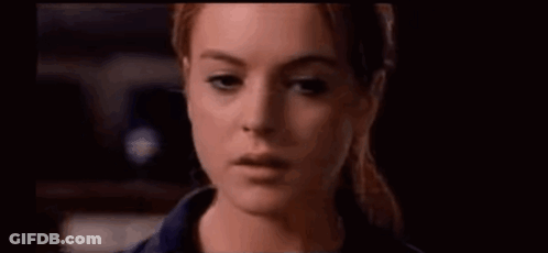 A Close Up Of A Woman 'S Face With A Ponytail In A Dark Room . GIF