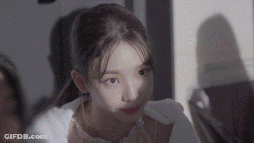 A Close Up Of A Woman 'S Face With A Ponytail Looking At The Camera . GIF