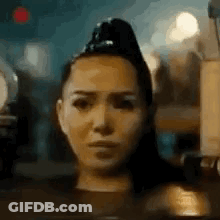 A Close Up Of A Woman 'S Face With A Ponytail On Her Head . GIF