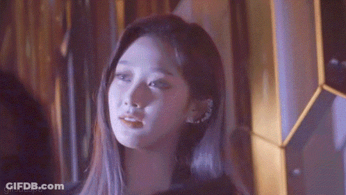 A Close Up Of A Woman 'S Face With A Purple Background GIF