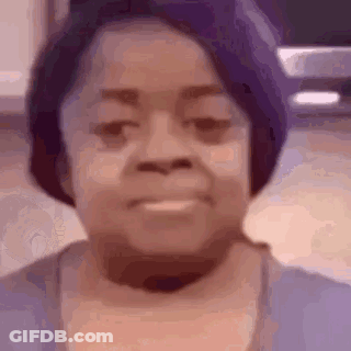A Close Up Of A Woman 'S Face With A Purple Hat And A Purple Shirt . GIF
