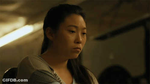 A Close Up Of A Woman 'S Face With A Purse Around Her Neck GIF