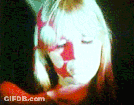 A Close Up Of A Woman 'S Face With A Red And White Floral Pattern On It GIF