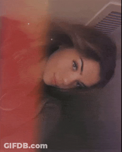A Close Up Of A Woman 'S Face With A Red And Yellow Background GIF