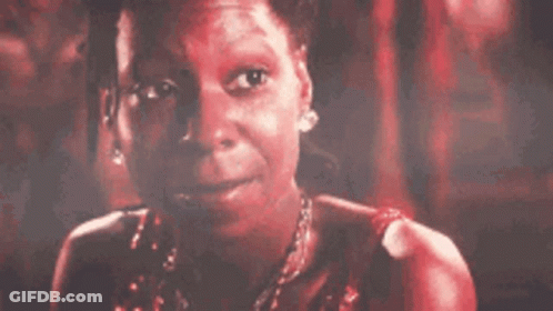 A Close Up Of A Woman 'S Face With A Red Background And A Necklace . GIF