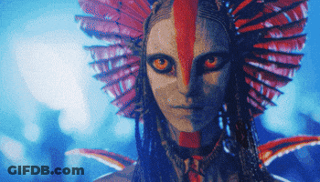 A Close Up Of A Woman 'S Face With A Red Feathered Headpiece GIF