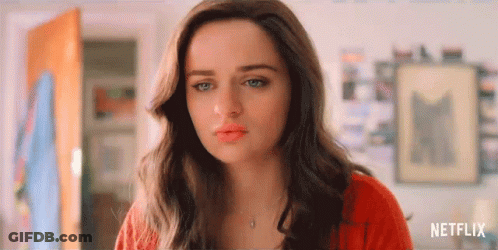 A Close Up Of A Woman 'S Face With A Red Sweater And Necklace . GIF