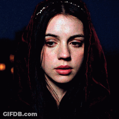 A Close Up Of A Woman 'S Face With A Red Veil Covering Her Head GIF