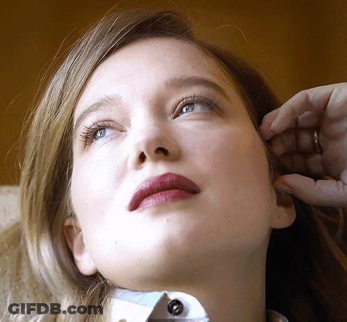 A Close Up Of A Woman 'S Face With A Ring In Her Hand GIF