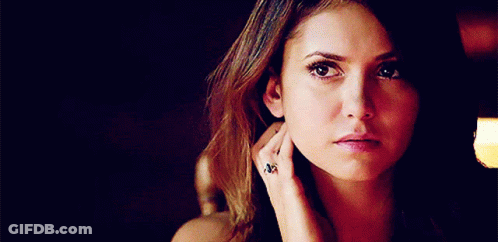 A Close Up Of A Woman 'S Face With A Ring On Her Finger . GIF