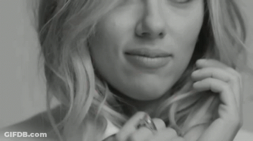 A Close Up Of A Woman 'S Face With A Ring On Her Finger . GIF
