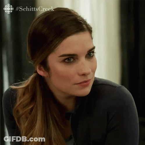 A Close Up Of A Woman 'S Face With A #Schitts Creek Logo In The Background GIF