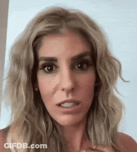 A Close Up Of A Woman 'S Face With A Serious Look On Her Face GIF