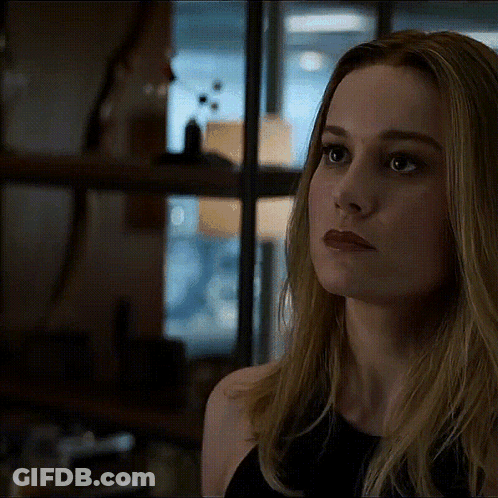 A Close Up Of A Woman 'S Face With A Serious Look On Her Face In A Dark Room . GIF