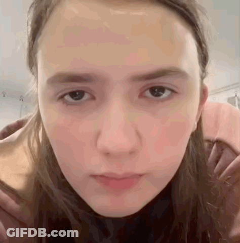 A Close Up Of A Woman 'S Face With A Serious Look On Her Face GIF