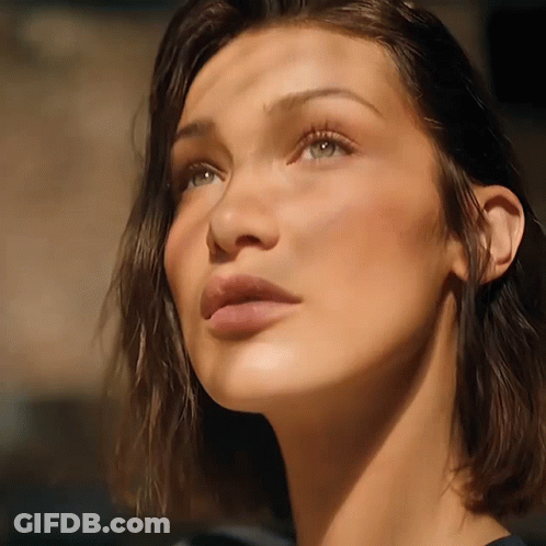 A Close Up Of A Woman 'S Face With A Shadow On Her Face GIF