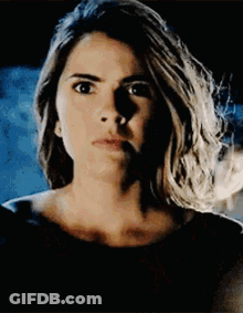 A Close Up Of A Woman 'S Face With A Shadow On Her Face And A Black Background . GIF