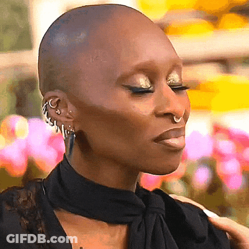 A Close Up Of A Woman 'S Face With A Shaved Head And Nose Ring GIF