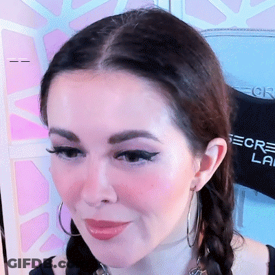 A Close Up Of A Woman 'S Face With A Shirt Behind Her That Says Secret Lab GIF