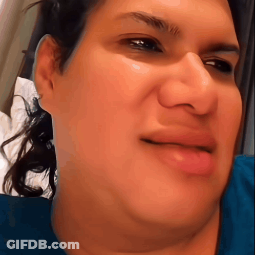 A Close Up Of A Woman 'S Face With A Slight Smile On Her Face GIF
