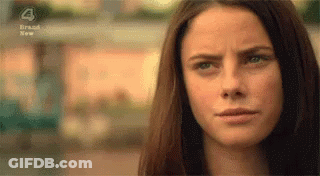 A Close Up Of A Woman 'S Face With A Slight Smile On Her Face . GIF