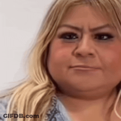 A Close Up Of A Woman 'S Face With A Slight Smirk On Her Face GIF