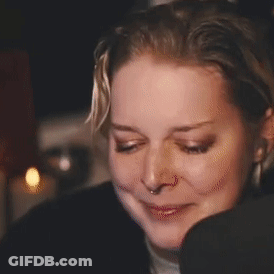 A Close Up Of A Woman 'S Face With A Smiley Face On It . GIF