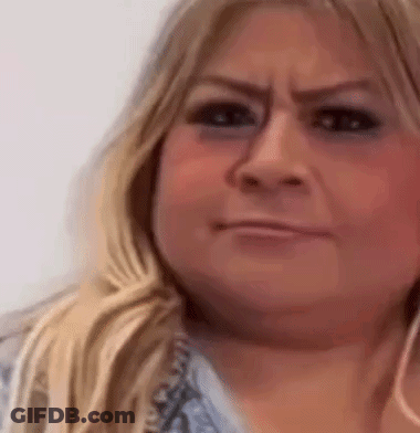 A Close Up Of A Woman 'S Face With A Smirk On Her Face . GIF