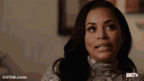 A Close Up Of A Woman 'S Face With A Snake Print Sweater On . GIF