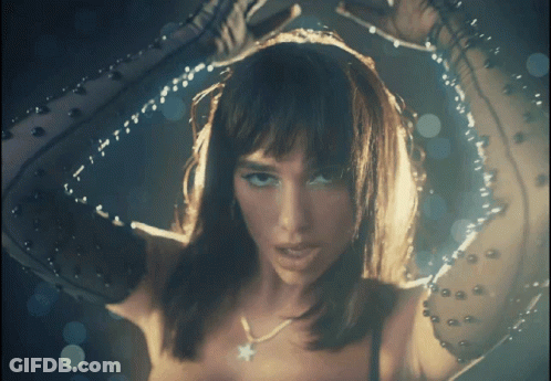 A Close Up Of A Woman 'S Face With A Star Necklace On Her Neck GIF