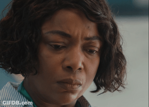 A Close Up Of A Woman 'S Face With A Striped Shirt GIF