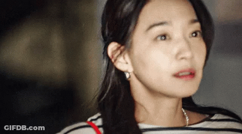 A Close Up Of A Woman 'S Face With A Striped Shirt On . GIF