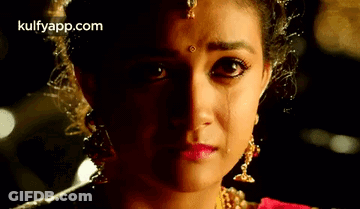 A Close Up Of A Woman 'S Face With A Tear Coming Out Of Her Eyes . GIF