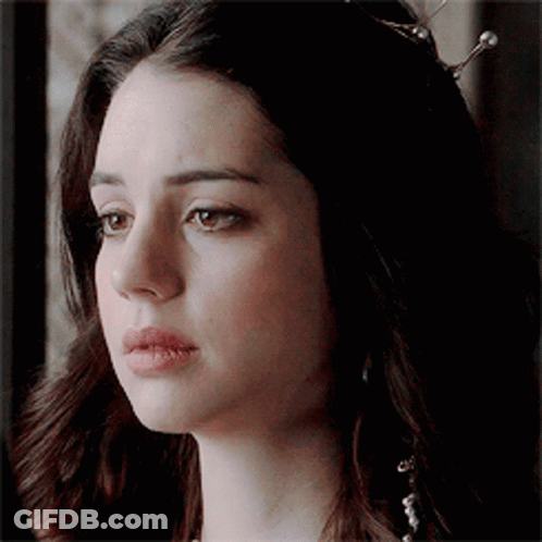 A Close Up Of A Woman 'S Face With A Tiara On Her Head . GIF