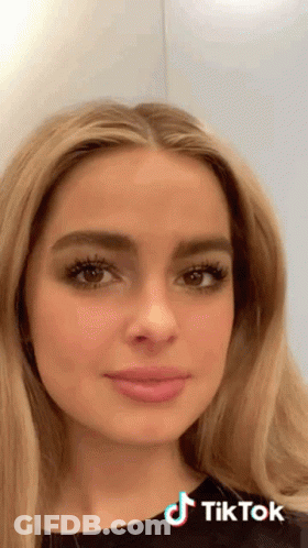 A Close Up Of A Woman 'S Face With A Tiktok Logo On The Bottom Right GIF