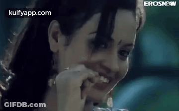 A Close Up Of A Woman 'S Face With A Toothpick In Her Mouth . GIF