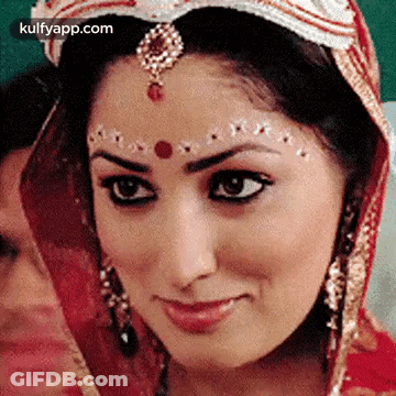A Close Up Of A Woman 'S Face With A Veil On Her Head And A Bindi On Her Forehead . GIF
