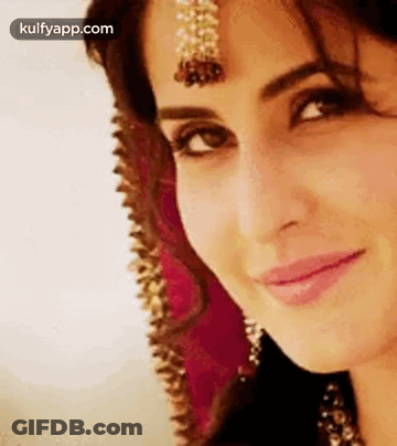 A Close Up Of A Woman 'S Face With A Veil On Her Head And A Smile On Her Face . GIF