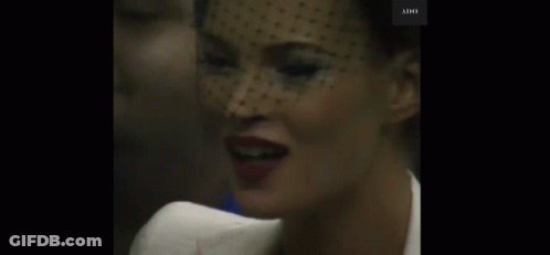 A Close Up Of A Woman 'S Face With A Veil On Her Head . GIF