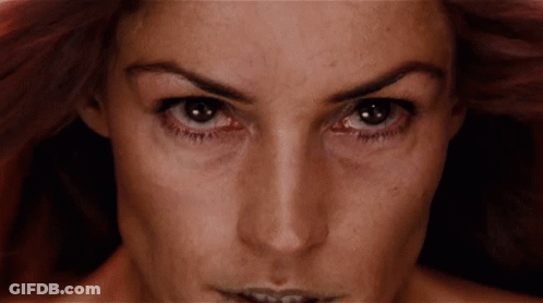 A Close Up Of A Woman 'S Face With A Very Dark Background GIF